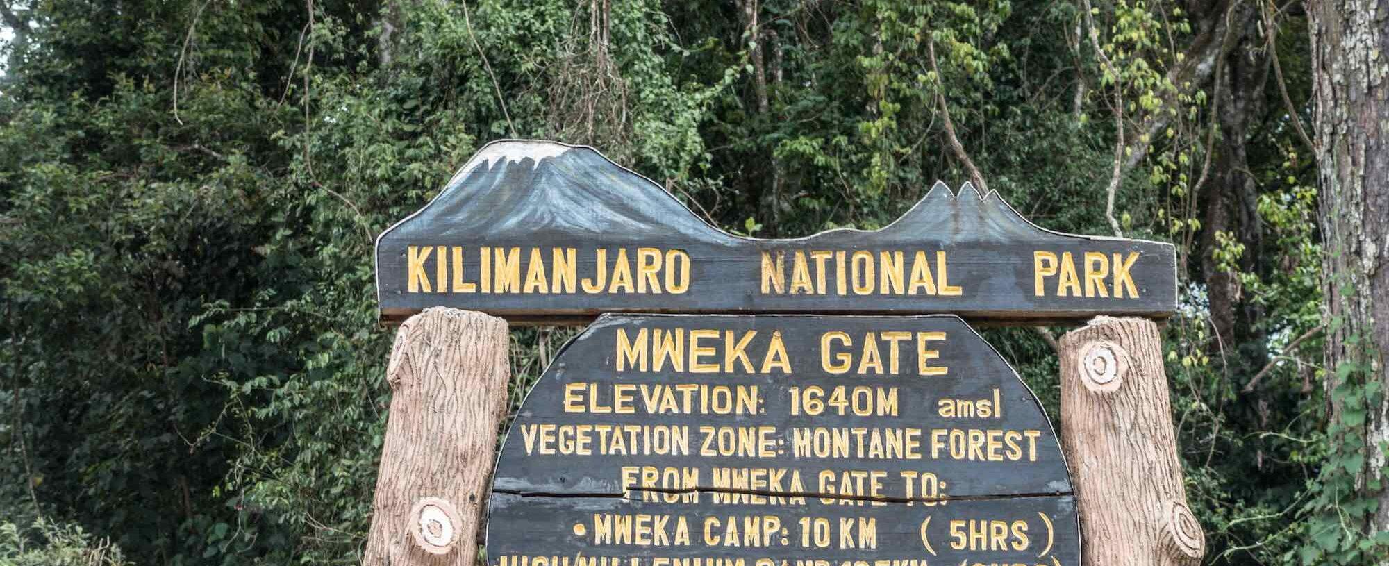 The wooden Kilimanjaro National Park sign at Mweka Gate, 1,650 m