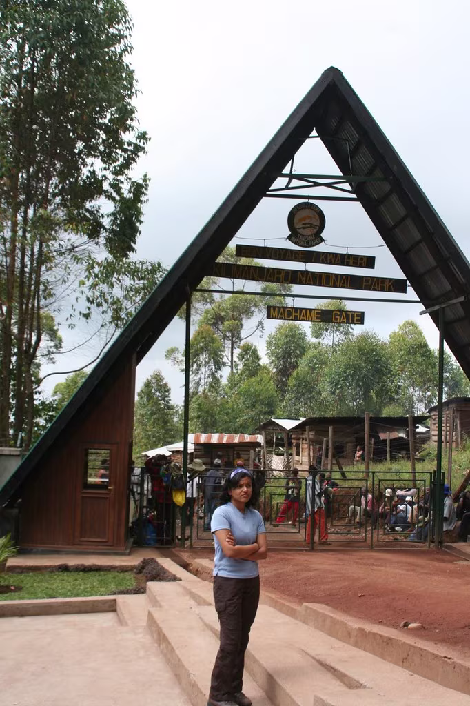 The wooden entrance arch at Machame Gate, with rainforest behind