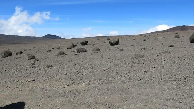 Flat, stony alpine desert under a blue sky