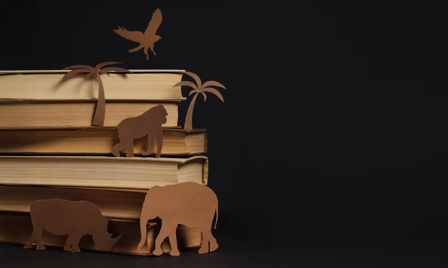 Paper animal cut-outs on a stack of books