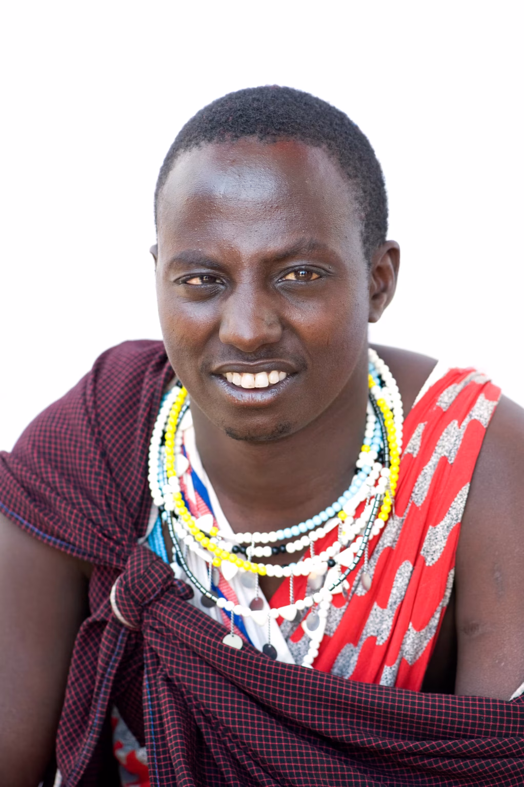A young Maasai man in a red shuka and beads